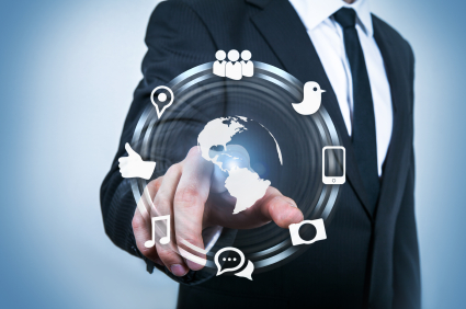 A person in a suit points to a digital interface displaying icons that represent various forms of technology and communication, including a globe, people, a bird, a smartphone, a camera, a music note, a chat bubble, and even the Public Sector "Likes" Facebook - and other social media.