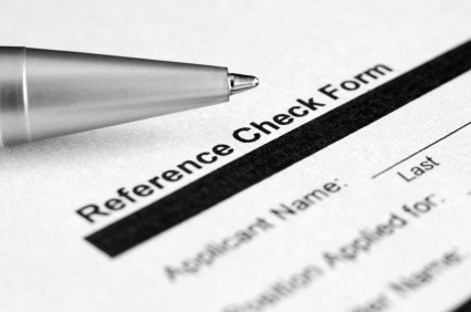 A close-up image of a form titled "Reference Check Form." A pen rests on the upper left corner of the form near the title. The form includes fields for the applicant's name and references, with other details partially visible in the shot. The image is in black and white.