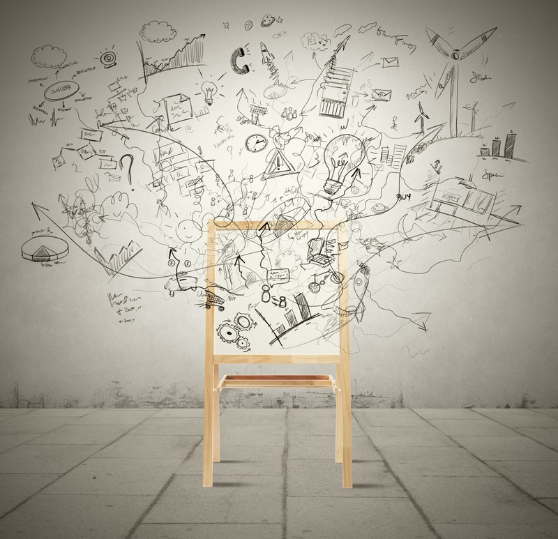 A wooden chair sits against a wall covered in sprawling black doodles and sketches. The imaginative drawings, possibly by a public policy analyst in their downtime, feature elements such as light bulbs, gears, buildings, and arrows, giving a dynamic and creative atmosphere. The floor is tiled in light gray.