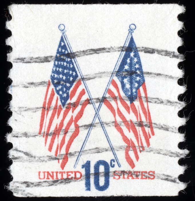 A 10-cent United States postage stamp featuring two crossed American flags. The flags are printed in red and blue ink. "UNITED STATES" is printed in red at the bottom, with "10¢" in large blue letters. The stamp, reminiscent of public-private partnerships, shows cancellation marks.
