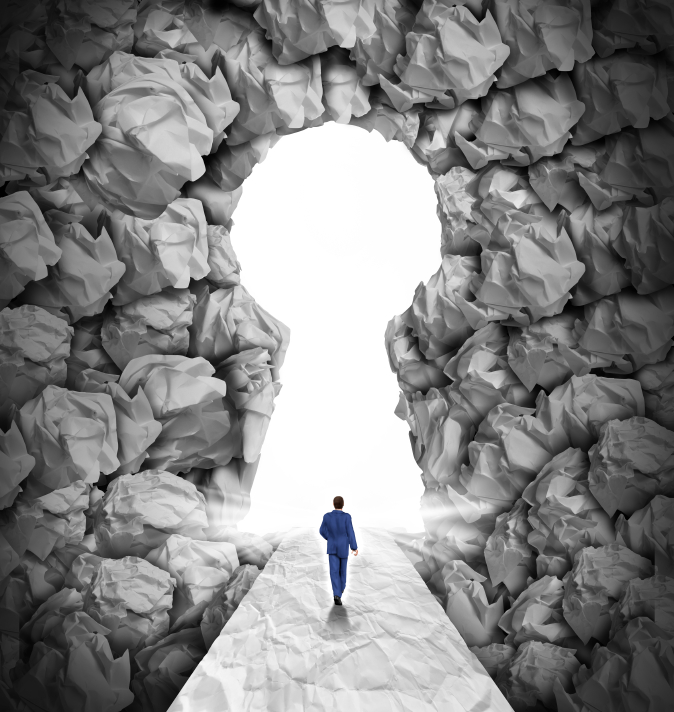 A person in a blue suit walks on a path made of crumpled paper, as if navigating the pages of an old resume, towards a keyhole-shaped opening in a wall of crumpled paper. The keyhole is illuminated with bright white light, creating a sense of opportunity or breakthrough.