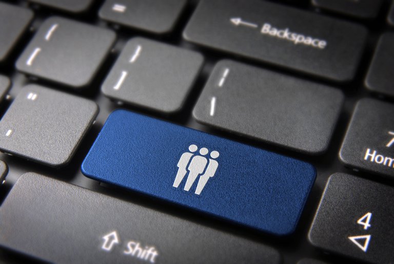 Close-up of a computer keyboard with a blue key featuring an icon depicting three standing human figures, symbolizing HR. The surrounding keys are black, with labels such as "Home" and "Backspace" visible.