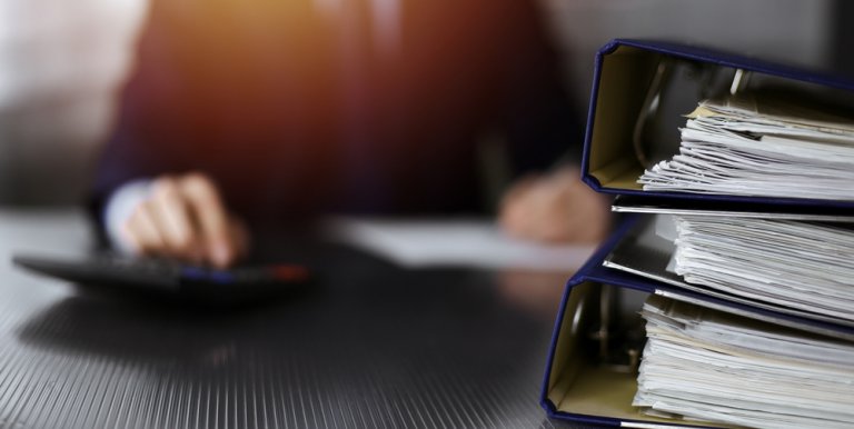 A man signing some documents in the background
