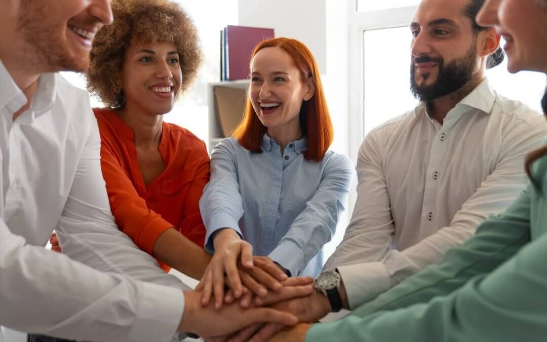 A group of people taking happily taking an oath putting palms together